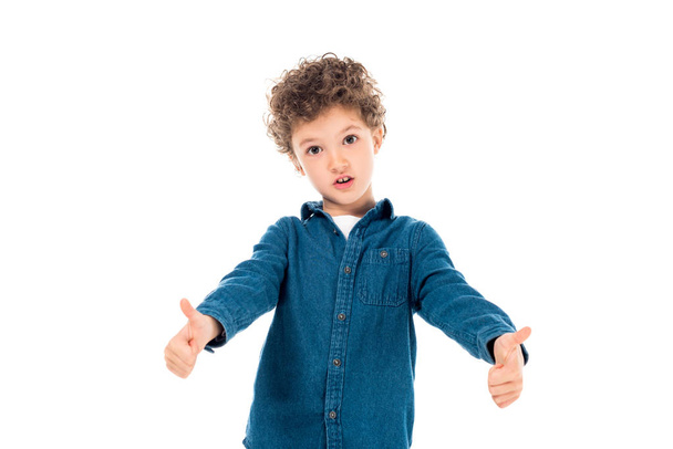 emotional kid in denim shirt showing thumbs up isolated on white - Φωτογραφία, εικόνα