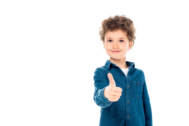 přední pohled na usmívající se dítě v džínové košili ukazující palec nahoru izolované na bílé - Fotografie, Obrázek