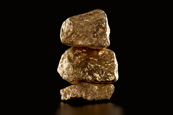 pile of gold textured shiny stones isolated on black - Foto, Imagen