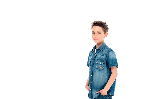 kid in denim shirt posing with hands in pockets isolated on white - Foto, imagen