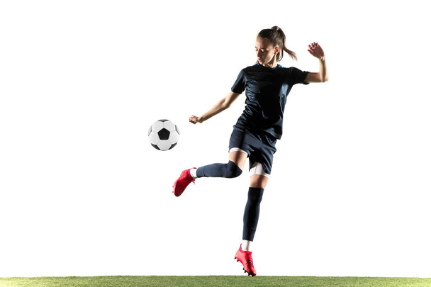 Θηλυκός ποδοσφαιριστής που κλωτσάει μπάλα απομονώνεται σε λευκό φόντο - Φωτογραφία, εικόνα