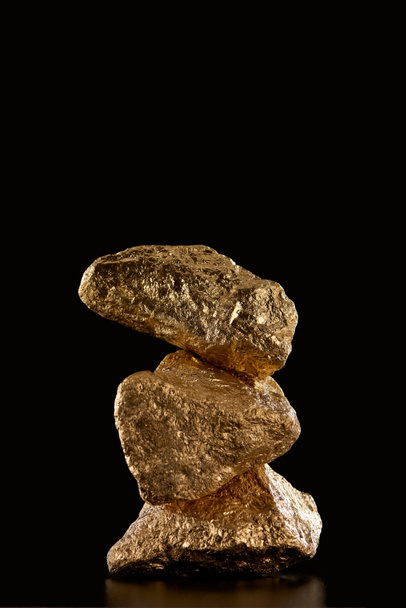 stack of gold textured stones isolated on black with copy space - Fotó, kép