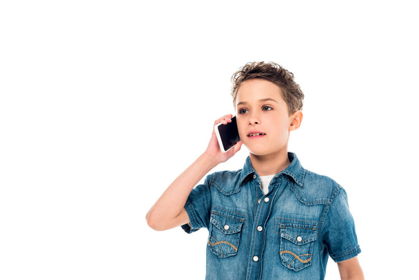 niño en camisa de mezclilla hablando en teléfono inteligente aislado en blanco
 - Foto, Imagen