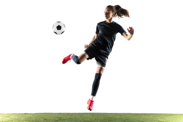 Vrouwelijke voetbalspeler schoppen bal geïsoleerd over witte achtergrond - Foto, afbeelding