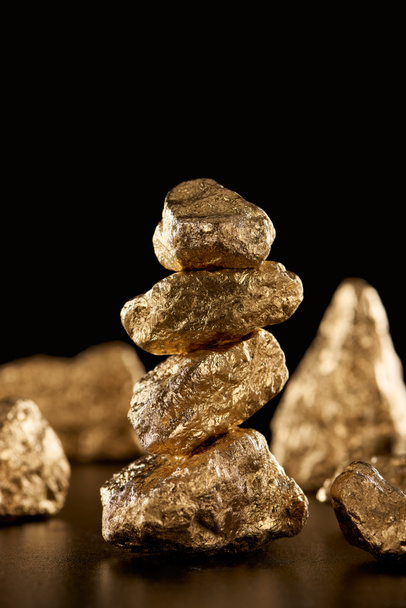 selective focus of golden shiny stones isolated on black with copy space - Foto, immagini