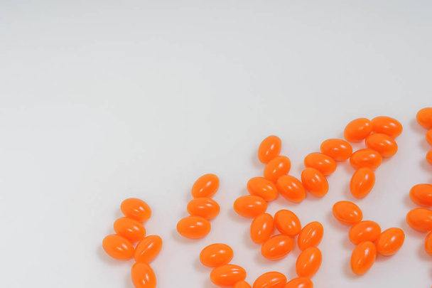 Orangefarbenes flüssiges veganes Softgel auf weißem Hintergrund. Nahrungsergänzungsmittel Coenzym q10. Veganes Coenzym ohne tierische Produkte. orange runde Kapsel Pillen auf weißem Hintergrund - Foto, Bild