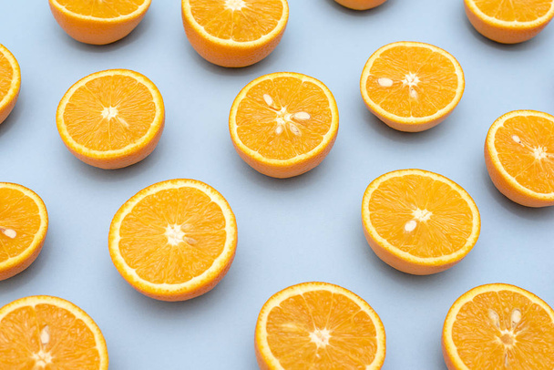 Naranjas jugosas de naranja divididas por la mitad en azul
 - Foto, Imagen