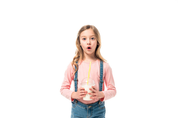 εμπρόσθια όψη του σοκαρισμένου παιδιού κρατώντας milkshake απομονώνονται σε λευκό - Φωτογραφία, εικόνα