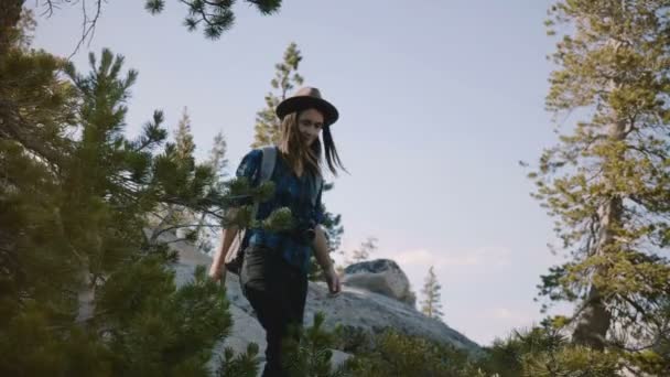 Beautiful active tourist girl hiking, walking down on big mountain stones exploring Yosemite national park slow motion. - Filmagem, Vídeo