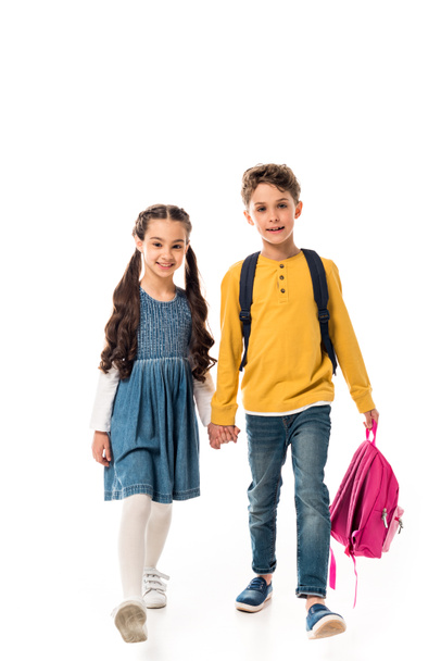 full length view of schoolchildren with backpacks holding hands isolated on white - Фото, зображення