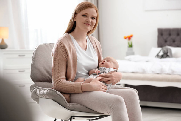 Mother with her little baby sitting in armchair at home - Photo, Image