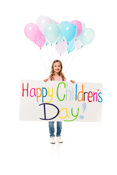 full length view of kid holding placard and balloons isolated on white - Foto, imagen