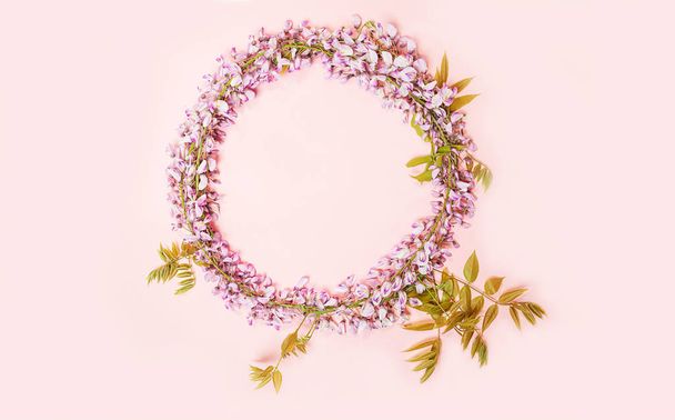 Circle frame of beautiful wisteria flowers branch with blossoms buds on pink background. - Fotografie, Obrázek