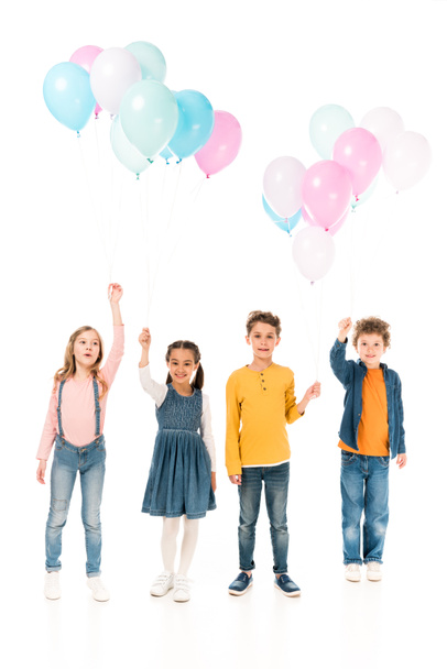 full length view of four kids holding balloons isolated on white - Foto, afbeelding