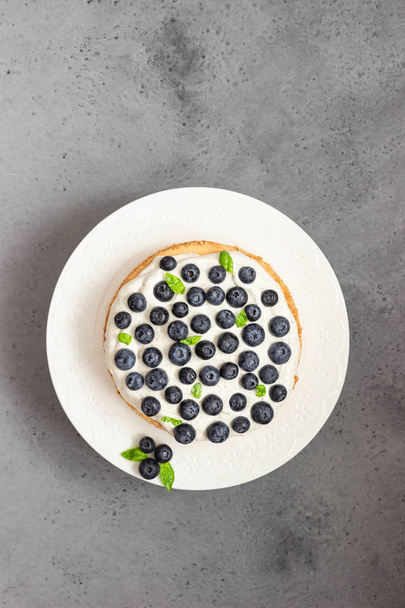 Angel food cake with whipped cream, fresh blueberries and basil.  - Photo, Image