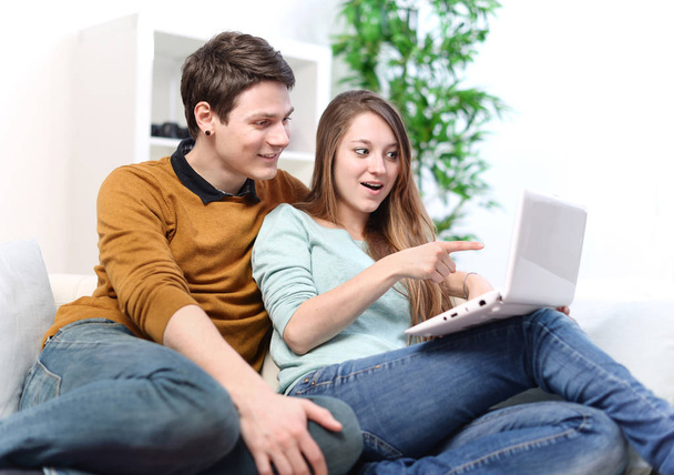 Attractive joyful woman showing something on its laptop computer to her boyfriend - Foto, Imagen