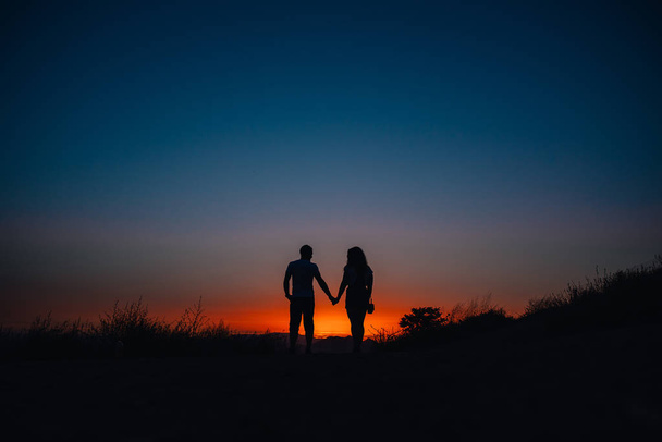 Young couple enjoying sunset in the mountains - Foto, Bild
