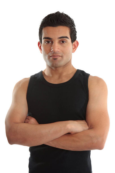 A personal trainer, fitness instructor, gymnast, tradesman or builder wearing a black tank top with arms crossed.  White background. - Fotoğraf, Görsel