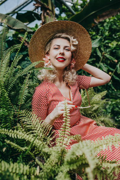 stylische Frau mit Hut posiert im tropischen Garten - Foto, Bild