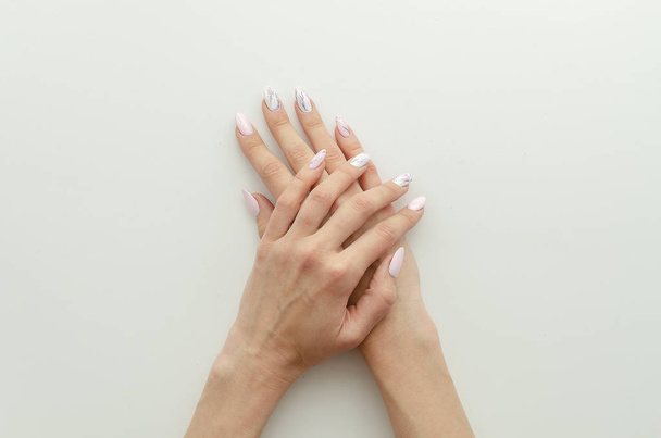 Platte lay vrouwelijke handen met manicure en Nail Painting draw. Flyer concept voor een schoonheidssalon met Kopieer ruimte op witte achtergrond - Foto, afbeelding