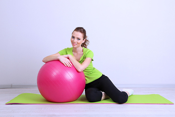 Portrait of beautiful young woman exercises with gym ball - Fotó, kép