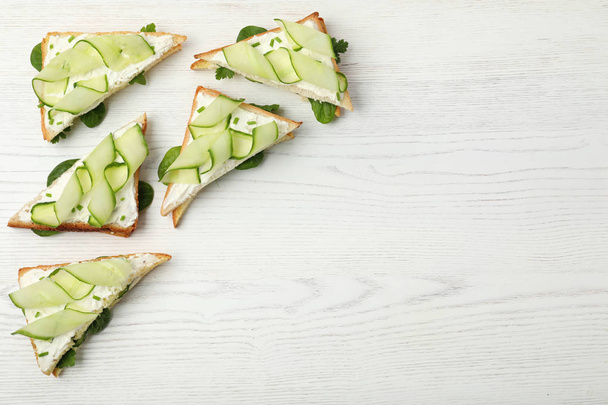 Flat lay composition with traditional English cucumber sandwiches on white wooden background. Space for text - Foto, Bild