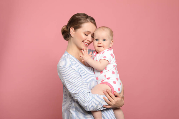 Portrait of happy mother with her baby on color background - Photo, Image