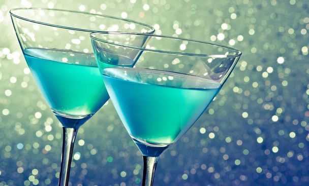 two glasses of blue cocktail on dark green tint light bokeh background on table - Zdjęcie, obraz