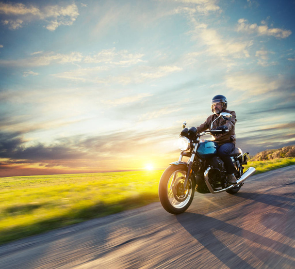 Motorcycle driver riding in European road - Photo, image