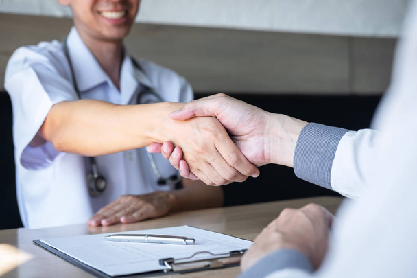 Doctor having shaking hands to congrats with patient after recom - Foto, imagen