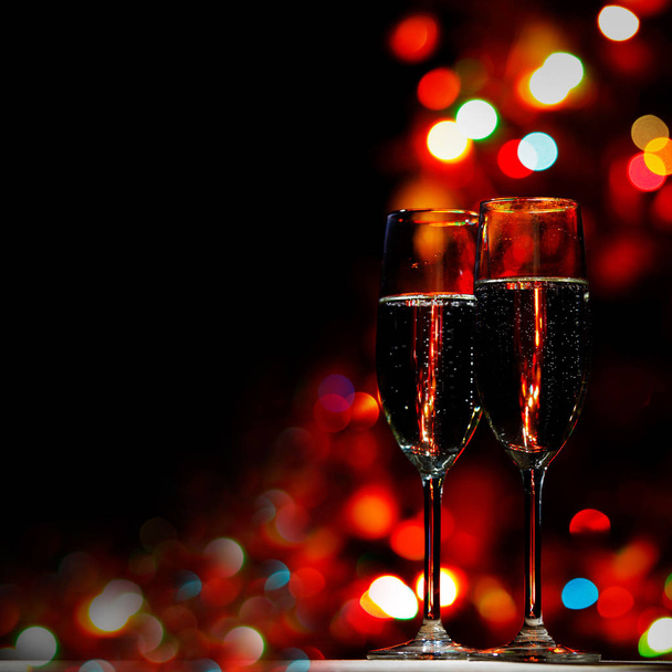 Two champagne glasses on color bokeh background - Foto, Imagen