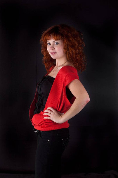 beautiful red hair woman in red dress on black - 写真・画像
