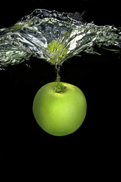 Green apple dropped into water - Foto, immagini
