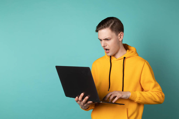 Hněvivý maneger ve žlutém hoodieho laptopu a křiku - Fotografie, Obrázek