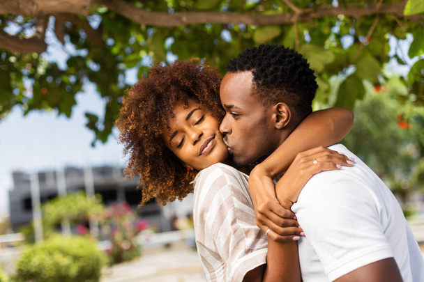 Outdoor protrait of black african american couple kissing each o - Фото, изображение