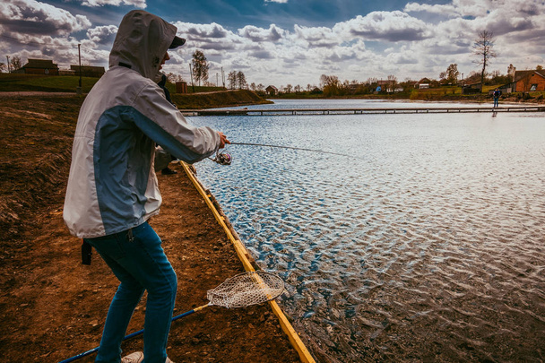 Young man fishing by lake - Photo, Image