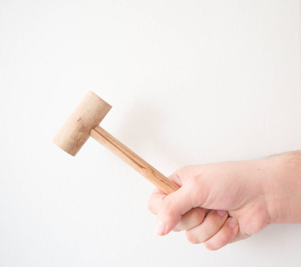 hand hitting with a wooden small hammer - Foto, Imagen