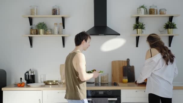 Young man an woman prepare breakfast in the good mood and dancing - Záběry, video