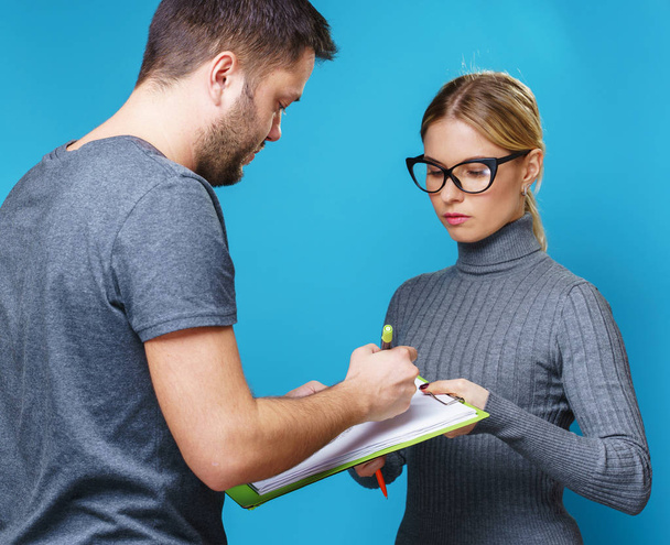Photo of woman in glasses with notebook in hand and man from back - Foto, imagen