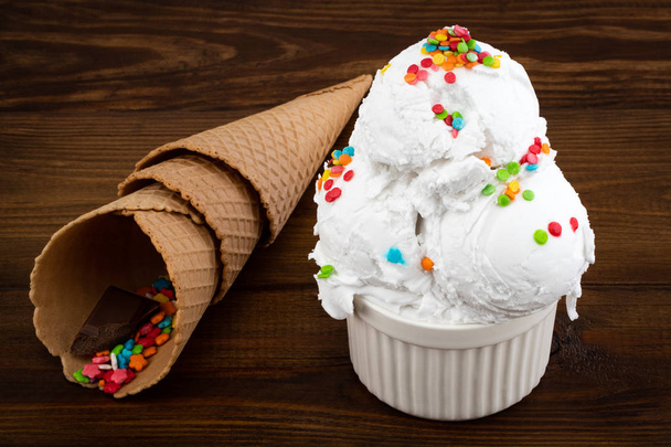 prato de sorvete de baunilha colher swith polvilhas e cone de waffle
 - Foto, Imagem