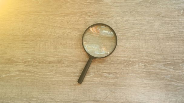 magnifying glass on the grey laminate background. Sun effect. - Foto, immagini