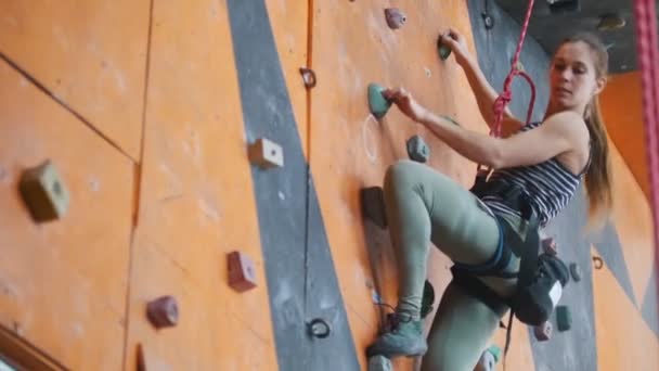 Bouldering. Mladá žena přicházející z skalnaté zdi - Záběry, video