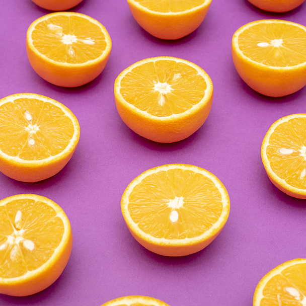 Naranjas jugosas de naranja divididas por la mitad en púrpura
 - Foto, imagen