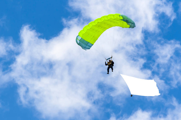 Яркий парашютист на фоне голубого неба
. - Фото, изображение