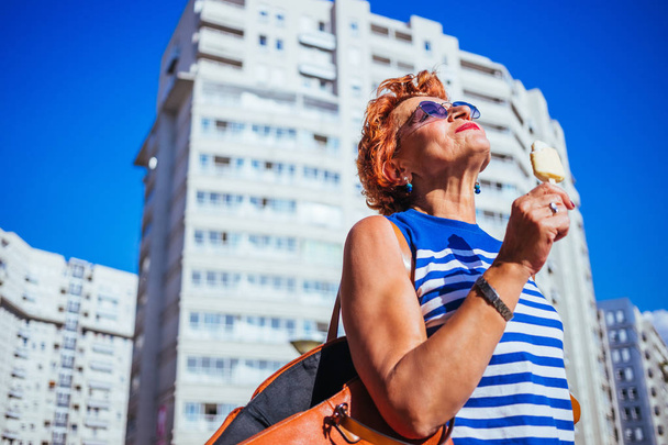 Dospělá žena požívající zmrzlinu za slunného horkého dne  - Fotografie, Obrázek