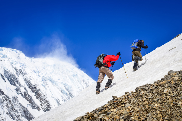 雪のピークの背景を持つ上の 2 つの山の登山者 - 写真・画像