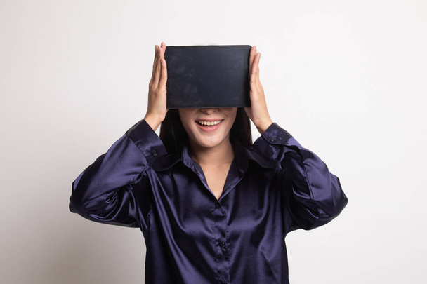 Young Asian woman with a computer tablet over her face. - Foto, Bild