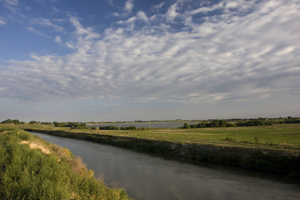 irrigation channel full of water, reservoir, and green meadows of north eastern Colorado farmland in late summer - Photo, Image