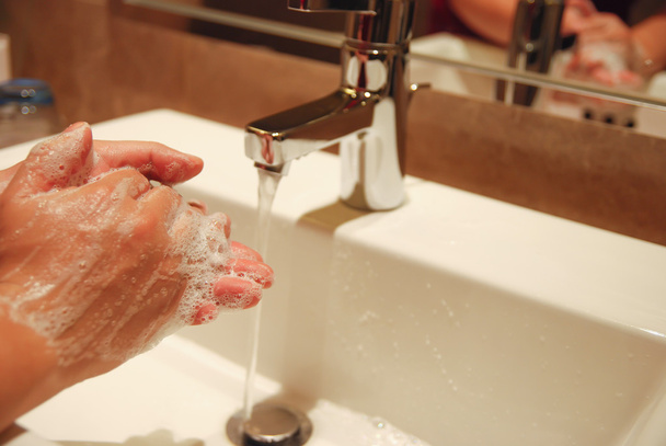 Πλένει τα χέρια με σαπούνι κάτω από τρεχούμενο νερό - Φωτογραφία, εικόνα