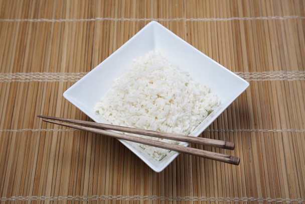 Bowl of white rice on tatami mat - Фото, изображение